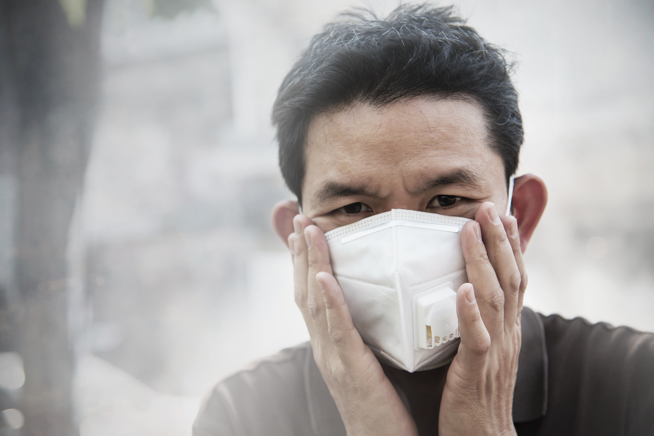 A man wearing a face mask breathing in dusty air