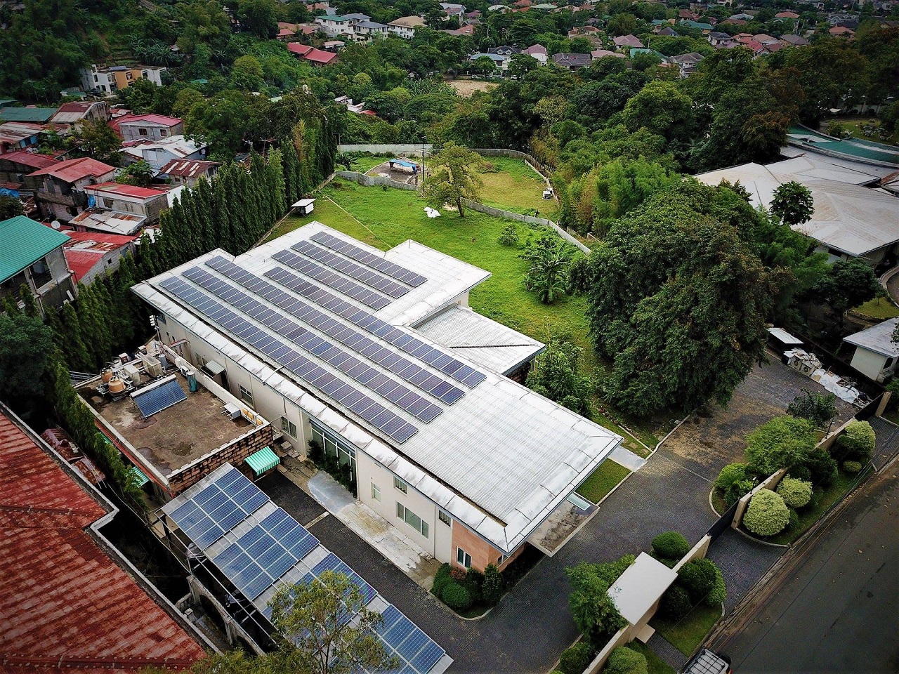 Drone shot of a white rooftop full of solar panels