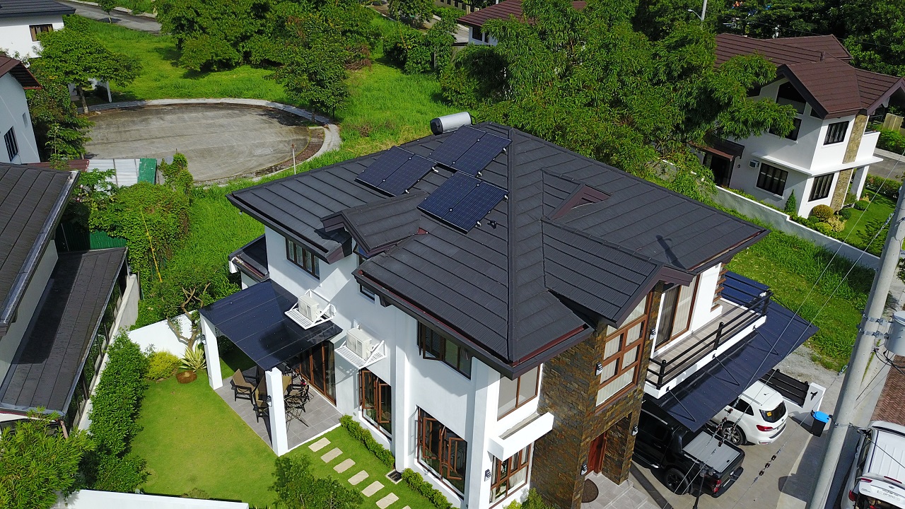 Top view of a dark roof of a house with solar panels