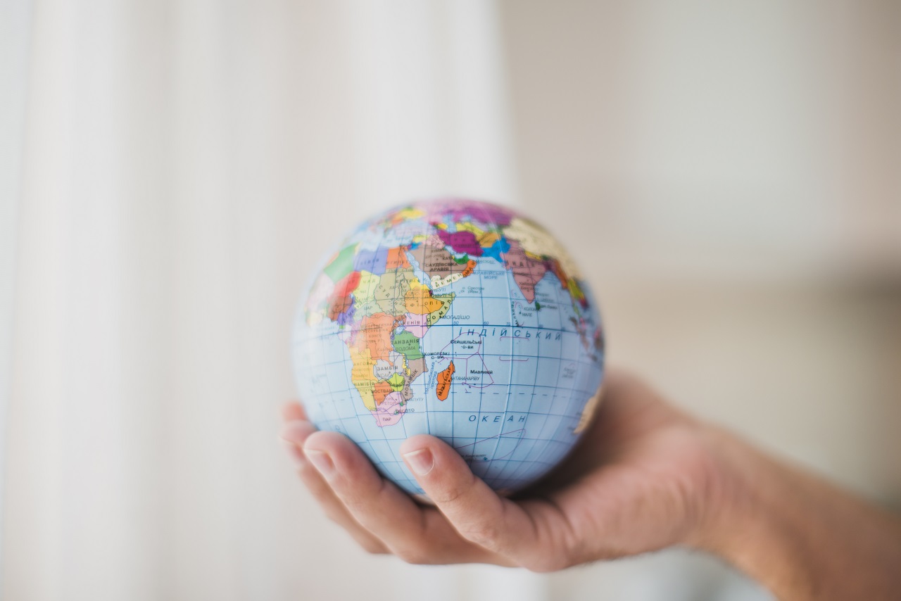 A hand holding a globe